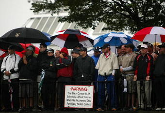 FARMINGDALE, NY - JUNE 18:  Fans watch the first tee ball of the championship in the rain during the first round of the 109th U.S. Open on the Black Course at Bethpage State Park on June 18, 2009 in Farmingdale, New York.  (Photo by Nick Laham/Getty Images)
