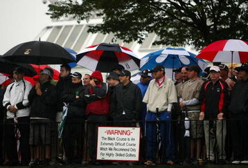 FARMINGDALE, NY - JUNE 18:  Fans watch the first tee ball of the championship in the rain during the first round of the 109th U.S. Open on the Black Course at Bethpage State Park on June 18, 2009 in Farmingdale, New York.  (Photo by Nick Laham/Getty Images)