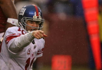 LANDOVER, MD - NOVEMBER 30:  Eli Manning #10 of the New York Giants runs points to his team against the Washington Redskins during their game at FedEx Field on November 30, 2008 in Landover, Maryland.  (Photo by Streeter Lecka/Getty Images)