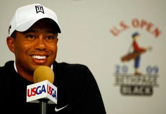 FARMINGDALE, NY - JUNE 16:  Tiger Woods smiles during a press conference held on the second day of previews to the 109th U.S. Open on the Black Course at Bethpage State Park on June 16, 2009 in Farmingdale, New York.  (Photo by Scott Halleran/Getty Images)