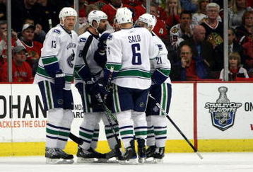 CHICAGO - MAY 11:  Mats Sundin #13, Willie Mitchell #8, Sami Salo and Mason Raymond #21 of the Vancouver Canucks celebrate after Raymond scored a goalin the second period as Niklas Hjalmarsson #4 of the Chicago Blackhawks skates towards the bench during Game Six of the Western Conference Semifinal Round of the 2009 Stanley Cup Playoffs on May 11, 2009 at the United Center in Chicago, Illinois.  (Photo by Jonathan Daniel/Getty Images)