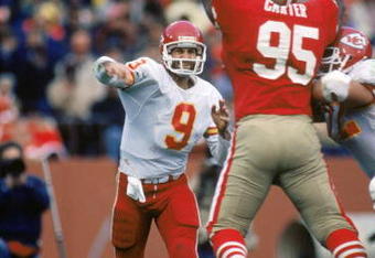 SAN FRANCISCO - NOVEMBER 17:  Quarterback Bill Kenney #9 of the Kansas City Chiefs attempts to pass over defensive linemen Michael Carter #95 of the San Francisco 49ers during a game at Candlestick Park on November 17, 1985 in San Francisco, California.  The 49ers won 31-3.  (Photo by George Rose/Getty Images)