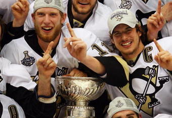 DETROIT - JUNE 12:  The Pittsburgh Penguins celebrate with the Stanley Cup after defeating the Detroit Red Wings by a score of 2-1 to win Game Seven and the 2009 NHL Stanley Cup Finals at Joe Louis Arena on June 12, 2009 in Detroit, Michigan.  (Photo by Jim McIsaac/Getty Images)