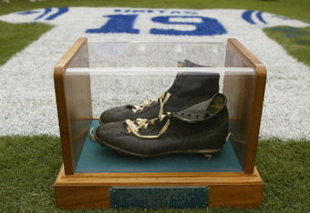 BALTIMORE - SEPTEMBER  15:  On display are the famous black high top shoes worn by Johnny Unitas while completing his last touchdown pass as a Colt on December 3, 1972.  A jersey painted with his name and uniform number on the grass is in the background.  The Baltimore Ravens paid tribute to Johnny Unitas prior to the start of the game against the Tampa Bay Buccaneers on September 15, 2002 at Ravens Stadium in Baltimore, Maryland.  The Baltimore Colts' Hall of Fame quarterback died of a heart attack September 11 at age 69.  The Buccaneers shut out the Ravens 25-0.  (Photo By Scott Halleran/Getty Images)