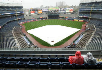 NEW YORK - JUNE 18:  Two fans sit during a rain delay before the game between the New York Yankees and the Washington Nationals on June 18, 2009 at Yankee Stadium in the Bronx Borough of New York City.  (Photo by Al Bello/Getty Images)