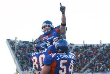BOISE, ID - NOVEMBER 20:  Running back Jon Helmandollar #33 of Boise State is hoisted up by teammates Andy Weldon #80 and Jeff Cavender #54 after scoring a touchdown in the fourth quarter against Louisiana Tech at Bronco Stadium on November 20, 2004 in Boise, Idaho. Boise State defeated Louisiana Tech 55-14. (Photo by Jeff Gross/Getty Images)
