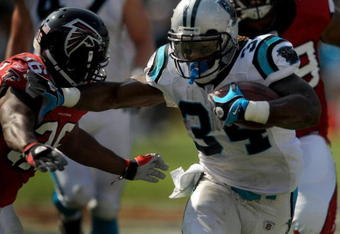 CHARLOTTE, NC - SEPTEMBER 28:  Running back DeAngelo Williams #34 of the Carolina Panthers stiff arms Safety Lawyer Malloy #36 of the Atlanta Falcons in the third quarter of the game at Bank of America Stadium on September 28, 2008 in Charlotte, North Carolina. The Carolina Panthers won the game 24-9. (Photo by Steve Dykes/Getty Images)