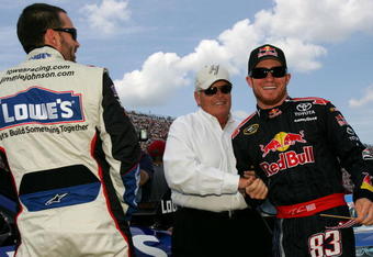 BROOKLYN, MI - JUNE 14:  Jimmie Johnson (L), driver of the #48 Lowe's Chevrolet, talks with team owner Rick Hendrick (C) and Brian Vickers (R), driver of the #83 Red Bull Toyota, before the NASCAR Sprint Cup Series LifeLock 400 at Michigan International Speedway on June 14, 2009 in Brooklyn, Michigan.  (Photo by Todd Warshaw/Getty Images for NASCAR)