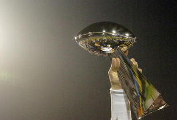 Tom Brady holds the Vince Lombardi Trophy as he stands on the podium after The New England Patriots defeated The Philadelphia Eagles in Super Bowl XXXIX at Alltel Staduim in Jacksonville, Florida.  (Photo by Al Messerschmidt/Getty Images)
