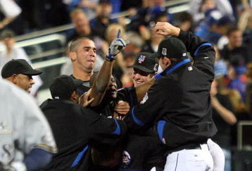 NEW YORK - APRIL 17:  Luis Castillo #1 of the New York Mets is mobbed by his teammates after his game winning infield walk off hit against the Milwaukee Brewers on April 17, 2009 at Citi Field in the Flushing neighborhood of the Queens borough of New York City.  (Photo by Jim McIsaac/Getty Images)