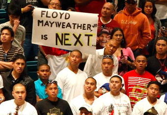 LAS VEGAS - MAY 01:  A sign for Floyd Mayweather Jr. is held as boxing fans wait for the official weigh-in for the junior welterweight title fight between Ricky Hatton of England and Manny Pacquiao of the Philippines at the MGM Grand Garden Arena May 1, 2009 in Las Vegas, Nevada. It was reported that on May 2 Mayweather will announce the end of his retirement to fight Juan Manuel Marquez.  (Photo by Ethan Miller/Getty Images)