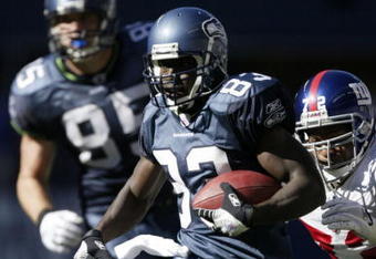 SEATTLE - SEPTEMBER 24:   Wide receiver Deion Branch #83 of the Seattle Seahawks is tackled by Osi Umenyiora #72 of the New York Giants at Qwest Field September 24, 2006 in Seattle, Washington.  (Photo by Otto Greule Jr/Getty Images)