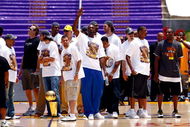 LOS ANGELES, CA - JUNE 17:  (L-R) Derek Fisher, assistant coach Kurt Rambis, Sasha Vujacic, Andrew Bynum, Jordan Farmar, head coach Phil Jackson, Lamar Odom (C), Shannon Brown, Pau Gasol, Adam Morrison, Trevor Ariza and Kobe Bryant of the Los Angeles Lakers celebrate on stage during the 2009 NBA Championship Victory Parade at the Los Angeles Memorial Coliseum on June 17, 2009 in Los Angeles, California.  (Photo by Jeff Gross/Getty Images)