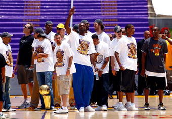 LOS ANGELES, CA - JUNE 17:  (L-R) Derek Fisher, assistant coach Kurt Rambis, Sasha Vujacic, Andrew Bynum, Jordan Farmar, head coach Phil Jackson, Lamar Odom (C), Shannon Brown, Pau Gasol, Adam Morrison, Trevor Ariza and Kobe Bryant of the Los Angeles Lakers celebrate on stage during the 2009 NBA Championship Victory Parade at the Los Angeles Memorial Coliseum on June 17, 2009 in Los Angeles, California.  (Photo by Jeff Gross/Getty Images)
