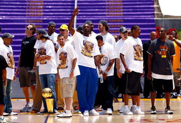 LOS ANGELES, CA - JUNE 17:  (L-R) Derek Fisher, assistant coach Kurt Rambis, Sasha Vujacic, Andrew Bynum, Jordan Farmar, head coach Phil Jackson, Lamar Odom (C), Shannon Brown, Pau Gasol, Adam Morrison, Trevor Ariza and Kobe Bryant of the Los Angeles Lakers celebrate on stage during the 2009 NBA Championship Victory Parade at the Los Angeles Memorial Coliseum on June 17, 2009 in Los Angeles, California.  (Photo by Jeff Gross/Getty Images)