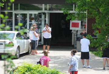 PARKERSBURG, IA - JUNE 24: Students and teachers gather near the entrance to Parkersburg elementary near where football coach  Ed Thomas was shot and killed by a former player on June 24, 2009 in Parkersburg, Iowa. Thomas had been a coach at Aplington-Parkersburg High School for 34 years. A 24-year-old suspect has been arrested.  (Photo by David Greedy/Getty Images)
