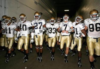 LOS ANGELES, CA - NOVEMBER 29:  Quarterback Jimmy Clausen #7 of the Notre Dame Fighting Irish walks out with teammates Robert Hughes #33 and Sergio Brown #31 before the game against the USC Trojans at Los Angeles Memorial Coliseum on November 29, 2008 in Los Angeles, California. The Trojans defeated the Fighting Irish 38-3.  (Photo by Christian Petersen/Getty Images)