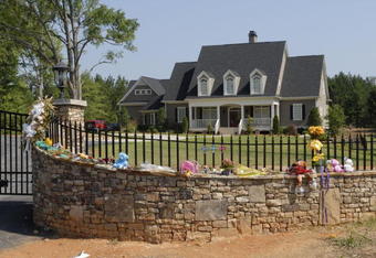 FAYETTEVILLE, GA - JULY 1: A make-shift shrine adorns the fence of the home of pro wrestler Chris Benoit July 1, 2007 in Fayetteville, Georgia. Police say Benoit killed his wife and seven year-old son, before hanging himself June 24 in the house. (Photo by Barry Williams/Getty Images)
