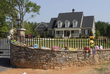 FAYETTEVILLE, GA - JULY 1: A make-shift shrine adorns the fence of the home of pro wrestler Chris Benoit July 1, 2007 in Fayetteville, Georgia. Police say Benoit killed his wife and seven year-old son, before hanging himself June 24 in the house. (Photo by Barry Williams/Getty Images)
