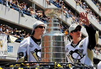 PITTSBURGH - JUNE 15:  Marc-Andre Fleury #29 and Sidney Crosby #87 of the Pittsburgh Penguins show off the Stanley Cup to the crowd on the Blvd of the Allies during the Stanley Cup Champion Victory Parade on June 15, 2009 in Pittsburgh, Pennsylvania.  (Photo by Jamie Sabau/Getty Images)