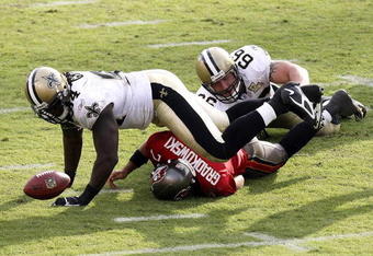 TAMPA, FL - NOVEMBER 05:  Defensive tackle Brian Young #66 of the New Orleans Saints finishes a sack on quarterback Bruce Gradkowski #7 of the Tampa Bay Buccaneers as Charles Grant #94 of the Saints recovers Gradkowski's fumble in the fourth quarter on November 5, 2006 at Raymond James Stadium in Tampa, Florida. The Saints defeated the Bucs 31-14.  (Photo by Doug Benc/Getty Images)