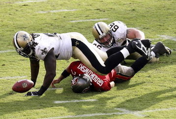 TAMPA, FL - NOVEMBER 05:  Defensive tackle Brian Young #66 of the New Orleans Saints finishes a sack on quarterback Bruce Gradkowski #7 of the Tampa Bay Buccaneers as Charles Grant #94 of the Saints recovers Gradkowski's fumble in the fourth quarter on November 5, 2006 at Raymond James Stadium in Tampa, Florida. The Saints defeated the Bucs 31-14.  (Photo by Doug Benc/Getty Images)