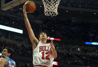 CHICAGO - FEBRUARY 22: Kirk Hinrich #12 of the Chicago Bulls lays the ball in for a basket between Eduardo Najera #21 and Anthony Carter #25 of the Denver Nuggets on February 22, 2008 at the United Center in Chicago, Illinois. NOTE TO USER: User expressly acknowledges and agreees that, by downloading and/or using this Photograph, User is consenting to the terms and conditions of the Getty Images License Agreement. (Photo by Jonathan Daniel/Getty Images)