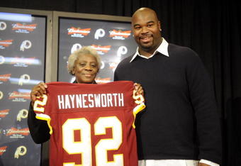 ASHBURN, VA - FEBRUARY 27:  Albert Haynesworth #92 and his mom Linda pose with his team jersey at a press conference after signing a 7-year contract worth approximately $100 million with the Washington Redskins on February 27, 2009 at Redskins Park in Ashburn, Virginia.  (Photo by Mitchell Layton/Getty Images)