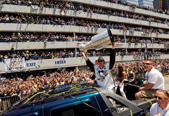 PITTSBURGH - JUNE 15:  Sidney Crosby #87 of the Pittsburgh Penguins holds the Stanley Cup aloft for the fans along the Blvd of the Allies during the Stanley Cup Champion Victory Parade on June 15, 2009 in Pittsburgh, Pennsylvania.  (Photo by Jamie Sabau/Getty Images)