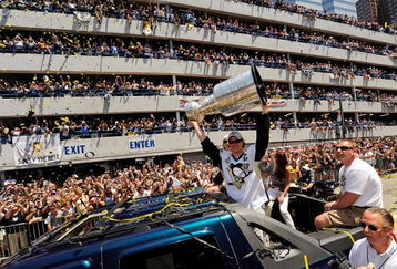 PITTSBURGH - JUNE 15:  Sidney Crosby #87 of the Pittsburgh Penguins holds the Stanley Cup aloft for the fans along the Blvd of the Allies during the Stanley Cup Champion Victory Parade on June 15, 2009 in Pittsburgh, Pennsylvania.  (Photo by Jamie Sabau/Getty Images)
