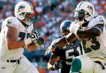 MIAMI - NOVEMBER 09:  Running back Ronnie Brown #23 of the Miami Dolphins shakes a tackle attempt by safety Deon Grant #24 of the Seattle Seahawks to score a fourth quarter touchdown at Dolphin Stadium on November 9, 2008 in Miami, Florida. The Dolphins defeated the Seahawks 21-19.  (Photo by Doug Benc/Getty Images)