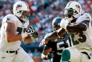 MIAMI - NOVEMBER 09:  Running back Ronnie Brown #23 of the Miami Dolphins shakes a tackle attempt by safety Deon Grant #24 of the Seattle Seahawks to score a fourth quarter touchdown at Dolphin Stadium on November 9, 2008 in Miami, Florida. The Dolphins defeated the Seahawks 21-19.  (Photo by Doug Benc/Getty Images)