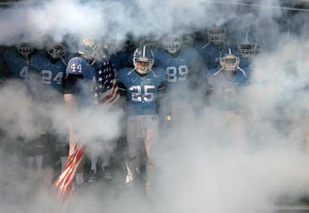CHAPEL HILL, NC - NOVEMBER 22:  Matt Merletti #25 of the North Carolina Tar Heels carries the American Flag as he leads his team before the start of their game against the North Carolina State Wolfpack at Kenan Stadium on November 22, 2008 in Chapel Hill, North Carolina.  (Photo by Streeter Lecka/Getty Images)