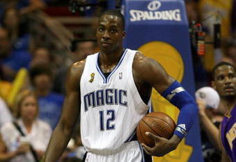 ORLANDO, FL - JUNE 14:  Dwight Howard #12 of the Orlando Magic holds the ball under the basket in the second half against the Los Angeles Lakers in Game Five of the 2009 NBA Finals on June 14, 2009 at Amway Arena in Orlando, Florida.  NOTE TO USER:  User expressly acknowledges and agrees that, by downloading and or using this photograph, User is consenting to the terms and conditions of the Getty Images License Agreement.  (Photo by Elsa/Getty Images)