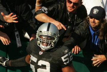 OAKLAND, CA - DECEMBER 3:  Kirk Morrison #52 of the Oakland Raiders celebrates with fans after scoring a touchdown against the Houston Texans during the second quarter of an NFL game on December 3, 2006 at McAfee Coliseum in Oakland, California.  (Photo by Stephen Dunn/Getty Images)