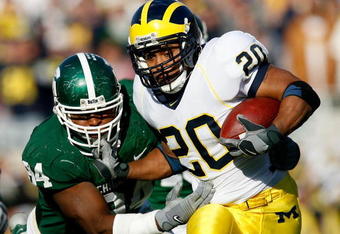 EAST LANSING, MI - NOVEMBER 03:  Running back Mike Hart #20 of the Michigan Wolverines stiff arms the facemask of defensive end Jonal Saint-Dic #94 of the Michigan State Spartans during the first half at Spartan Stadium November 3, 2007 in East Lansing, Michigan.  (Photo by Kevin C. Cox/Getty Images)