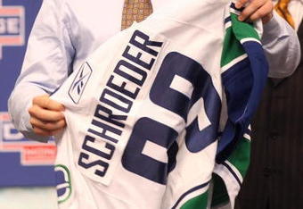 MONTREAL, QC - JUNE 26:  Jordan Schroeder puts on a new Vancouver Canucks sweater after he was selected #22 overall by the Canucks during the first round of the 2009 NHL Entry Draft at the Bell Centre on June 26, 2009 in Montreal, Quebec, Canada.  (Photo by Bruce Bennett/Getty Images)