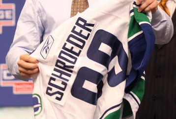 MONTREAL, QC - JUNE 26:  Jordan Schroeder puts on a new Vancouver Canucks sweater after he was selected #22 overall by the Canucks during the first round of the 2009 NHL Entry Draft at the Bell Centre on June 26, 2009 in Montreal, Quebec, Canada.  (Photo by Bruce Bennett/Getty Images)