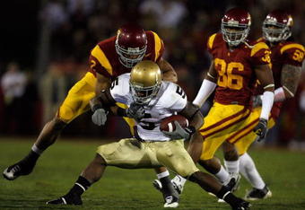 LOS ANGELES, CA - NOVEMBER 29:  Armando Allen #5 of the Nortre Dame Fighting Irsh is stopped by Taylor Mays #2, Josh Pinkard #36 and Rey Maualuga #58 of the USC Trojans during the second quarter at the Coliseum on November 29, 2008 in Los Angeles, California.  (Photo by Harry How/Getty Images)