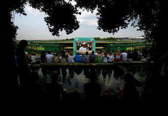 WIMBLEDON, ENGLAND - JUNE 29:  Spectators watch the Andy Murray of Great Britain v Stanislas Wawrinka of Switzerland men's singles fourth round match on the big screens from Murray Mount on Day Seven of the Wimbledon Lawn Tennis Championships at the All England Lawn Tennis and Croquet Club on June 29, 2009 in London, England. The match is played under the closed Centre Court roof.  (Photo by Paul Gilham/Getty Images)