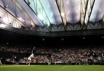 WIMBLEDON, ENGLAND - JUNE 29:  Andy Murray of Great Britain serves under the new Centre Court roof during the men's singles fourth round match against Stanislas Wawrinka of Switzerland on Day Seven of the Wimbledon Lawn Tennis Championships at the All England Lawn Tennis and Croquet Club on June 29, 2009 in London, England.  (Photo by Julian Finney/Getty Images)