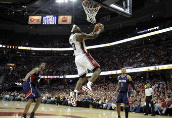 CLEVELAND - MAY 07:  LeBron James #23 of the Cleveland Cavaliers gets in for a first quarter dunk between Maurice Evans #1 and Solomon Jones #44 of the Atlanta Hawks during Game Two of the Eastern Conference Semifinals during the 2009 NBA Playoffs at Quicken Loans Arena on May 7, 2009 in Cleveland, Ohio.  NOTE TO USER: User expressly acknowledges and agrees that, by downloading and or using this photograph, User is consenting to the terms and conditions of the Getty Images License Agreement.  (Photo by Gregory Shamus/Getty Images)