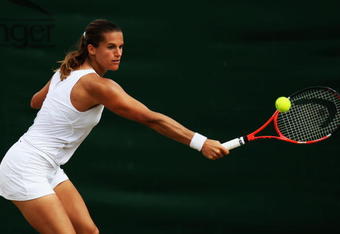 WIMBLEDON, ENGLAND - JUNE 27:  Amelie Mauresmo of France plays a backhand during the women's singles third round match against Flavia Pennetta of Italy on Day Six of the Wimbledon Lawn Tennis Championships at the All England Lawn Tennis and Croquet Club on June 27, 2009 in London, England.  (Photo by Ian Walton/Getty Images)