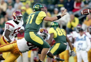 EUGENE, OR - SEPTEMBER 24:  Quarterback Kellen Clemens #11 of the Oregon Ducks pitches the ball against defensive end Frostee Rucker #90 of the USC Trojans on September 24, 2005 at Autzen Stadium in Eugene, Oregon. USC defeated Oregon 45-13.  (Photo by Jonathan Ferrey/Getty Images)