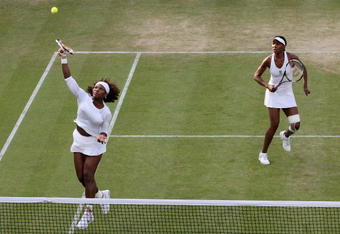 WIMBLEDON, ENGLAND - JUNE 29:  Serena Williams Venus Williams of USA (L) plays a smash playing Venus Williams with  of USA during the women's doubles third round match against Zi Yan of China and Jie Zheng of China on Day Seven of the Wimbledon Lawn Tennis Championships at the All England Lawn Tennis and Croquet Club on June 29, 2009 in London, England.  (Photo by Hamish Blair/Getty Images)