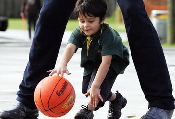 AUCKLAND, NEW ZEALAND - JUNE 29:  Five-year-old Boston Thompson dribbles the basketball through the legs of 7ft 6' Syrian player Abd Al Wahab Al Hamowi as the Syrian U19 basketball team visit Willow Bank School on June 29, 2009 in Auckland, New Zealand. The Syrian team are in New Zealand for the 2009 FIBA U19 World Champiosnhip.  (Photo by Hannah Johnston/Getty Images)