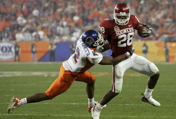 GLENDALE, AZ - JANUARY 1:  Adrian Peterson #28 of the Oklahoma Sooners looks to break a safety Gerald Alexander #2 of the Boise State Broncos tackle in the first half at the Tostito's Fiesta Bowl against the Boise State Broncos at University of Phoenix Stadium January 1, 2007 in Glendale, Arizona.  (Photo by Jonathan Ferrey/Getty Images)