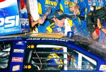 DAYTONA, FL - JULY 07: Jamie McMurray, driver of the #26 IRWIN Marathon Tools Ford, gets out of his car to celebrate with his crew members on victory lane after winning the NASCAR Nextel Cup Series Pepsi 400 at Daytona International Speedway on July 7, 2007 in Daytona, Florida.   (Photo by Rusty Jarrett/Getty Images for NASCAR)