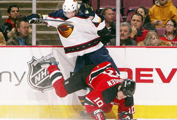 EAST RUTHERFORD, NJ - JANUARY 12:  Erik Rasmussen #10 of the New Jersey Devils takes a hit from Garnet Exelby #2 of the Atlanta Thrashers during their game on January 12, 2007 at Continental Airlines Arena in East Rutherford, New Jersey.   (Photo by Jim McIsaac/Getty Images)