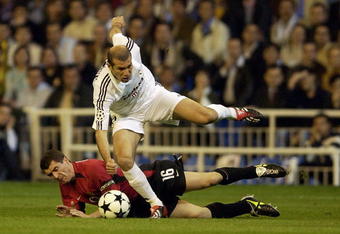 MADRID - APRIL 8:  Zinedine Zidane of Real Madrid uses his skill to take the ball past Roy Keane of Manchester United during the UEFA Champions League quarter-final first leg match held on April 8, 2003 at the Santiago Bernabeu Stadium, in Madrid, Spain. Real Madrid won the match 3-1. (Photo by Shaun Botterill/Getty Images)